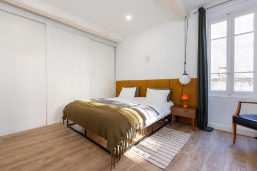 sypialnia z łóżkiem ze złotym kocem w obiekcie Le Vernet w Awinionie