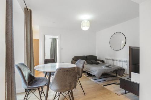 a living room with a table and chairs and a couch at Prime Location Flats in London