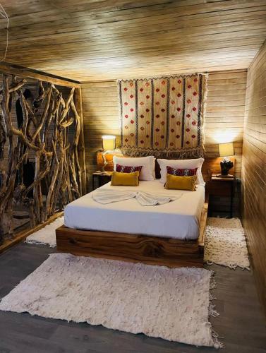 a bedroom with a large bed with a wooden headboard at Chalet au Calme à la Ferme in Fez