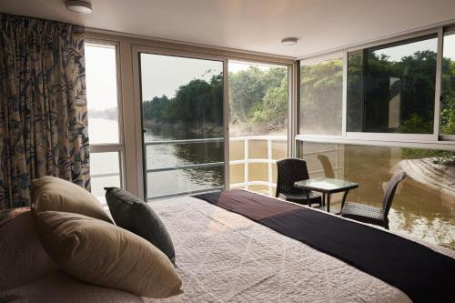 um quarto com uma cama e vista para um rio em El Manatí - River Experience em Iquitos