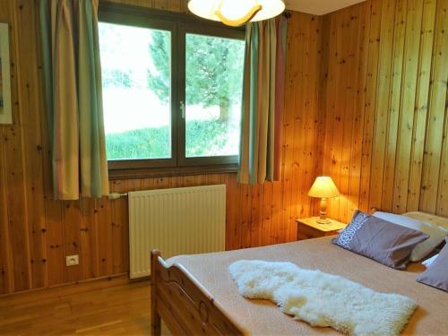 une chambre avec un lit avec des murs en bois et une fenêtre dans l'établissement Appartement 46m², 2 étoiles, 6 pers, au pied des pistes, Planay, proche Arêches - FR-1-342-153, à Beaufort