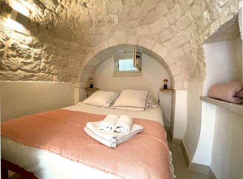 sypialnia z łóżkiem z ręcznikami w obiekcie Trullo Panna Fragola - Exclusive four bedroom Villa & Private pool w mieście Martina Franca