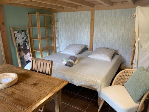 a room with two beds and a table and chairs at Studio Laina avec piscine, spa optionnel in Irissarry