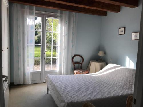 1 dormitorio con cama y ventana grande en Maison de vacances Sauzon en Sauzon
