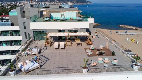 an aerial view of a building with a patio and the ocean at ME Sitges Terramar in Sitges