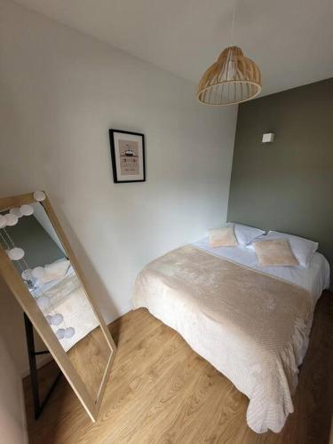 une petite chambre avec un lit et un miroir dans l'établissement Studio 2 voyageurs au cœur de ville, à Sallanches