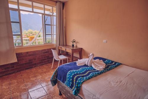 a bedroom with a bed with a desk and a window at Amigos in San Pedro La Laguna