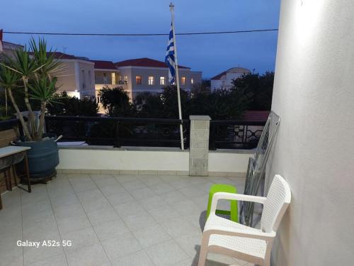 a balcony with two chairs and an american flag at Το σπίτι της Μαρίας in Chios