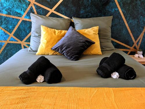 ein Bett mit vier schwarzen Kissen darauf in der Unterkunft Cosy Paris in Vitry-sur-Seine