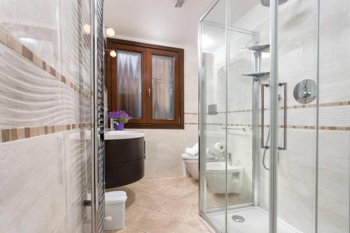 une salle de bains avec toilettes et douche en verre dans l'établissement Biennale Comfort House - modernità a Castello, à Venise