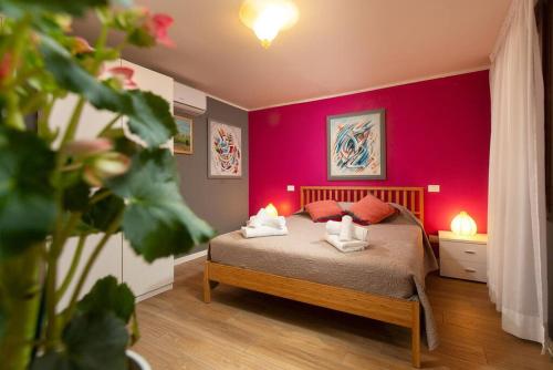 une chambre avec un lit avec un mur rouge dans l'établissement Biennale Comfort House - modernità a Castello, à Venise