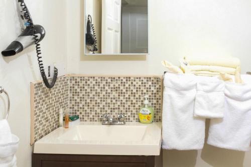 a bathroom with a sink and a mirror and towels at Spring Hotel Bequia in Port Elizabeth