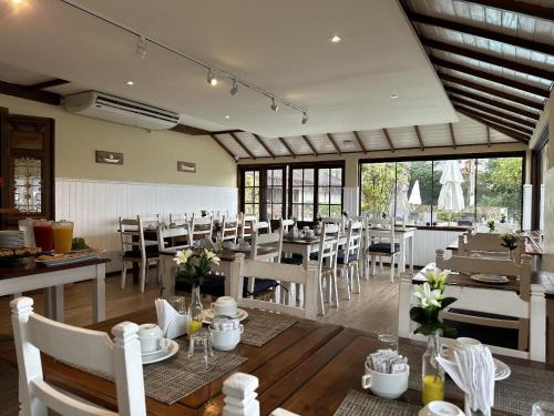 une salle à manger avec des tables et des chaises dans un restaurant dans l'établissement Pousada Corsario Buzios, à Búzios
