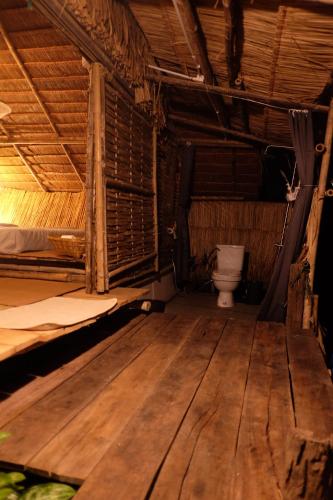 a bathroom with a toilet in a room with wooden floors at Royal mountain lake view in Ratchaburi