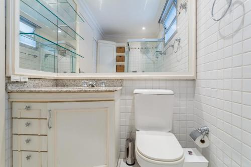 a bathroom with a toilet and a sink and a mirror at Ao lado do Shopping e da Beiramar Norte GB1800 in Florianópolis