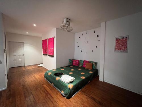 a bedroom with a bed and a clock on the wall at 77 Old Town in Bangkok