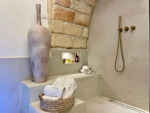 een badkamer met een douche, een vaas en handdoeken bij I Granai - Marea Collection in Nardò