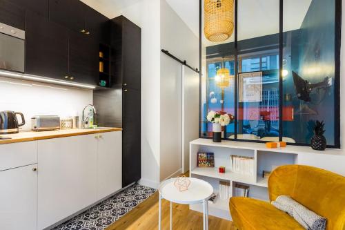 une cuisine avec une chaise jaune et une table dans l'établissement Cosy studio - Arc de Triomphe, à Paris