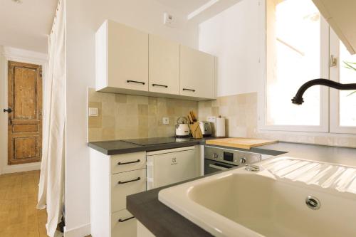 波爾多的住宿－By Homy，厨房配有大型白色水槽和窗户