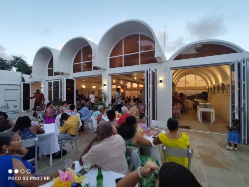 a group of people sitting at tables in a building at Spring Hotel Bequia in Port Elizabeth