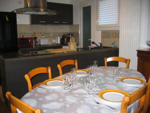 ein Tisch mit Stühlen und ein Tisch mit Weingläsern darauf in der Unterkunft les agrumes in Amélie-les-Bains-Palalda
