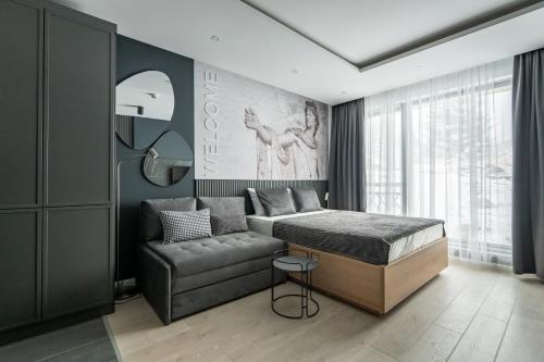 a bedroom with a bed and a couch and a mirror at Marrilux apartments Residence Hill in Kopaonik