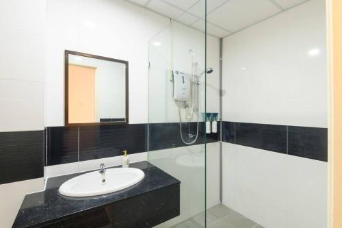 a bathroom with a sink and a glass shower at Deluxe Studio/Gurney/Mansion One in George Town
