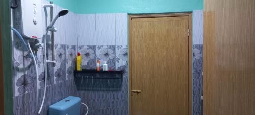 a bathroom with a door and a flower wallpaper at Beijing View Homestay in Rantau Panjang