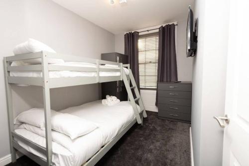 a bedroom with two bunk beds and a window at Lavish 2Bed Apartment in the Heart of Birkenhead in Birkenhead