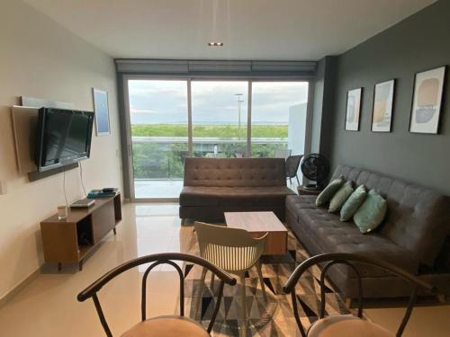 sala de estar con sofá y TV en Apartamento en Condominio con Salida al Mar MORROS EPIC, en Cartagena de Indias