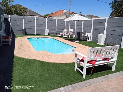 a small swimming pool in a yard with a bench at Palm Tree in Cape Town