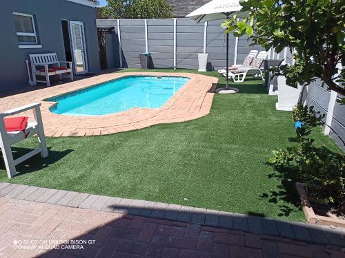 una piccola piscina in un cortile con prato di Palm Tree a Città del Capo