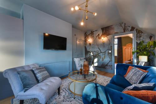 a living room with a blue couch and a table at Fairview Boutique Apartments in West Bridgford Centre in Nottingham