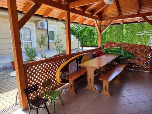 una terraza de madera con mesa y banco de madera en Pelso Apartments, en Siófok