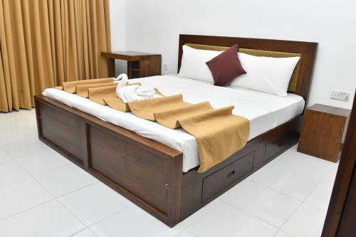 a bed with a wooden frame with a blanket on it at Urban Deck in Colombo