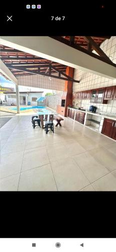 una mesa y bancos en un gran edificio en Maura oliveira en Boa Vista