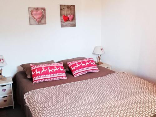 um quarto com uma cama com almofadas vermelhas e brancas em Appartement Saint-François-Longchamp, 2 pièces, 6 personnes - FR-1-635-41 em Saint-François-Longchamp