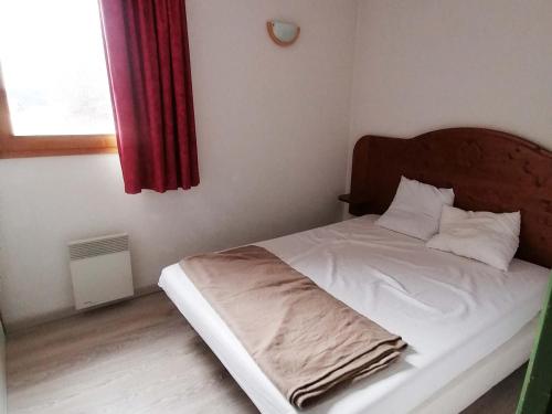 1 cama en un dormitorio con cortina roja en Appartement Saint-François-Longchamp, 2 pièces, 4 personnes - FR-1-635-49, en Saint-François-Longchamp