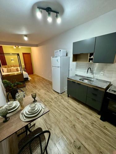 a kitchen with a table and a kitchen with a counter top at Apartamentos - Estúdios in São José