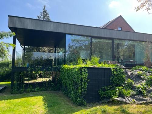 a glass house with a garden in front of it at Chez Arthur in Marche-en-Famenne