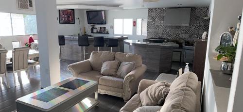 sala de estar con 2 sofás y cocina en CASA GRANDE CON VISTA AL VALLE 