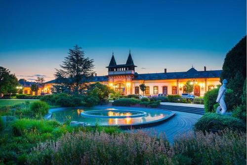 a large building with a fountain in front of it at Pelso Apartments in Siófok