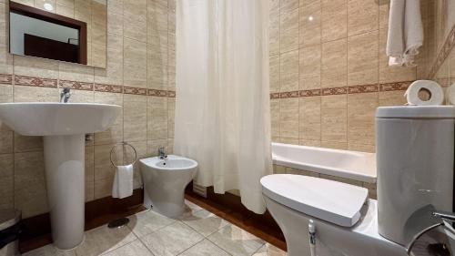 La salle de bains est pourvue d'un lavabo, de toilettes et d'une baignoire. dans l'établissement Hotel Avenida Praia, à Portimão