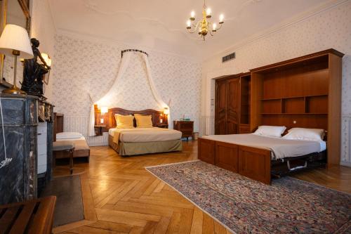 a bedroom with two beds and a chandelier at Cit'Hotel Sphinx - Hotel in Montélimar