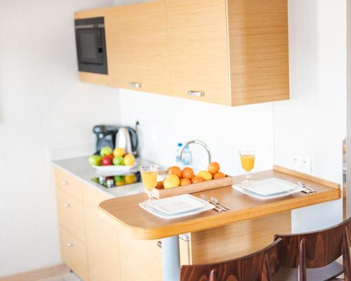 a kitchen with a wooden table with fruit on it at Hotel Marina Club Old Town View in Gdańsk