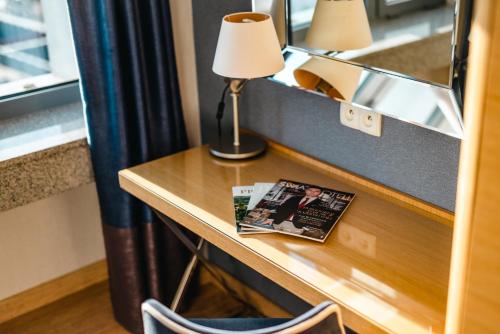 a desk with a lamp and a magazine on it at Hotel Marina Club Old Town View in Gdańsk
