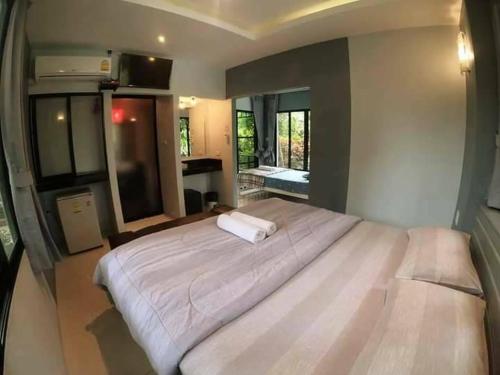 1 dormitorio con 1 cama blanca grande en una habitación en สวนผึ้ง2 รีสอร์ท - Suan Phueng 2 Resort, en Bang Sare