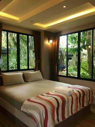 a large bed in a room with large windows at สวนผึ้ง2 รีสอร์ท - Suan Phueng 2 Resort in Bang Sare