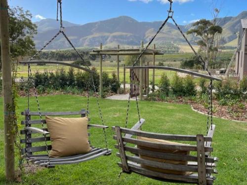 a wooden swing with a pillow in a yard at Rivergate Guest Farm in Stanford