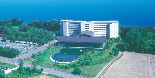 a large building with a pool in front of it at Kussharo Prince Hotel in Teshikaga